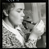 584 Brunsviks Folkhögskola. En ung kvinna röker pipa.