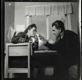 584 Brunsviks Folkhögskola. På studentrummet. En ung man tänder en ung kvinnas cigarett.