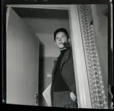 584 Brunsviks Folkhögskola. En man står i en dörröppning och röker pipa.