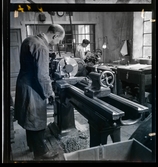 584 Brunsviks Folkhögskola. Ett par män arbetar vid maskiner i verkstad.