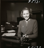 606 G, Åtvidabergs Industrier kontorsgymnastik. Porträtt av kvinna som arbetar vid skrivmaskin.