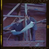 585/8 Facit Tokyo Daberg. Två män i kostym står på ett bygge och studerar en ritning.