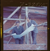 585/8 Facit Tokyo Daberg. Två män i kostym står på ett bygge och studerar en ritning.