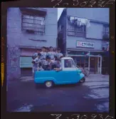 585/8 Facit Tokyo Daberg. Facit baseboll-lag poserar på flaket av en liten trehjulig bil.