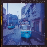 585/8 Facit Tokyo Daberg. Facit baseboll-lag poserar på flaket av en liten trehjulig bil.