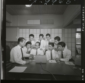 585/8 Facit Tokyo Daberg. En grupp män står samlade runt en Facit maskin.