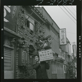 585/8 Facit Tokyo Daberg. En man bär en låda av trä på axeln, ute på gata.