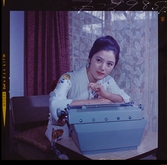 585/8 Facit Tokyo Daberg. Porträtt av en kvinna som sitter lutad över en Facit skrivmaskin.