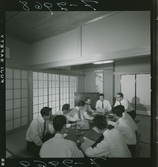 585/8 Facit Tokyo Daberg. En grupp män har möte i ett traditionellt japanskt rum.