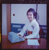 585/8 Facit Tokyo Daberg. Porträtt av en kvinna i kimono som arbetar vid en Facit maskin.