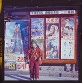 585/8 Facit Tokyo Daberg. Ett barn framför en vägg av (film?)affischer