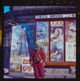 585/8 Facit Tokyo Daberg. Ett barn framför en vägg av (film?)affischer