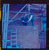 585/8 Facit Tokyo Daberg. Två män i kostym står på ett bygge och studerar en ritning.