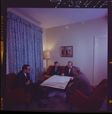 585/8 Facit Tokyo Daberg. En grupp män studerar ett stort ark med grafer.
