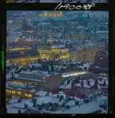 585/40 Facit Nattbild från N.K + Södra Kungstornet. Kvällsbild. Facit-skylt på taket av fastigheten Styrpinnen 22, ritad av arkitekt Ivar Tengbom i hörnet Hamngatan / Kungsträdgårdsgatan i Stockholm.