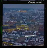 585/40 Facit Nattbild från N.K + Södra Kungstornet. Kvällsbild. Facit-skylt på taket av fastigheten Styrpinnen 22, ritad av arkitekt Ivar Tengbom i hörnet Hamngatan / Kungsträdgårdsgatan i Stockholm.