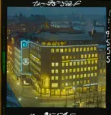 585/40 Facit Nattbild från N.K + Södra Kungstornet. Kvällsbild. Facit-skylt på taket av fastigheten Styrpinnen 22, ritad av arkitekt Ivar Tengbom i hörnet Hamngatan / Kungsträdgårdsgatan i Stockholm.