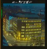 585/40 Facit Nattbild från N.K + Södra Kungstornet. Kvällsbild. Facit-skylt på taket av fastigheten Styrpinnen 22, ritad av arkitekt Ivar Tengbom i hörnet Hamngatan / Kungsträdgårdsgatan i Stockholm.