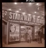 1690 New York, allmänt. En man köper biljett i kassan på biograf. Filmen som annonseras är 