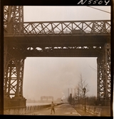 1690 New York allmänt (N.Y. Herald Tribune). George Washington bridge. En man passerar under bron.
