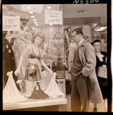 1690 New York allmänt (N.Y. Herald Tribune). En man framför ett skyltfönster. Butiken säljer damunderkläder.