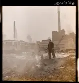 1690 New York allmänt (N.Y. Herald Tribune). Ett par män står på en rivningstomt vid en brasa av gammalt skrot.