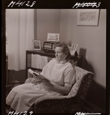 1711 En sjuksköterskas arbetsdag. En sköterska sitter och läser i en fåtölj.