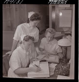 1711 En sjuksköterskas arbetsdag. Administration. Tre sköterskor för bok.