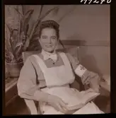 1714 En sjuksköterskas arbetsdag på södersjukhuset. Porträtt av en sköterska som sitter och läser i en bok.