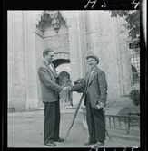 1717/K Istanbul allmänt. Fotograf K W Gullers skakar hand med en kollega, en gatufotograf som står vid sin kamera på lådkamera på stativ.