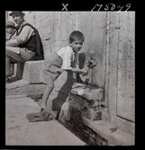 1717/L Istanbul allmänt. En pojke tvättar sig vid en springbrunn/ fontän.