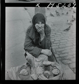 1717/L Istanbul allmänt. Gatuförsäljare. En kvinna sitter på trottoaren och säljer frön.