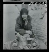 1717/L Istanbul allmänt. Gatuförsäljare. En kvinna sitter på trottoaren och säljer frön.