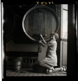 1950. Frankrike. flicka tappar ut vin från en tunna