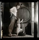 1950. Frankrike. en flicka och en man tappar ut vin från en tunna