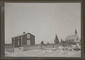 Fotografens anteckning: Fru Markströms gård med kyrkan i bakgrunden.