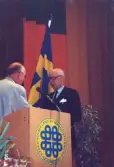 George Geeber blir hedersledamot vid årsmötet i Nacka 1997 och lämnar blommorna till fru Anne-Marie.