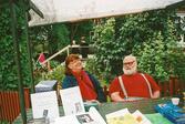 Britta Eriksson och Roland Isaksson säljer böcker på Hembygdsdräktens dag 2005.