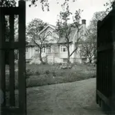 En bostad med fritrappa, frontespis, glasveranda och mansardtak.