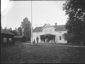 Grupporträtt framför hus. G. Olsson, Bärsta, Kolbäck
Ur Gustaf Åhmans samling.