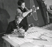 Två pojkar håller på med modellbygge av flygplan. Tillhör samlingen med fotokopior från Hallands Nyheter som är från 1930-1940-talen.