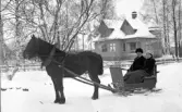 Ungt par med häst och släde utanför Ryssvillan