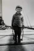 Lennart Blomdin på sin far Edwins pråm, släpande på kedjor i tidig ålder. Lennart drev under lång tid sin omtyckta verkstad på Björkö. Bilden är tagen ca 1943.