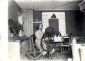 Lydia vid spinnrocken i köket, Hvilan 1920.