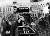 Stock car. Arne Welander, Falköping, vid sin Ford V8 85 hkr, 1935 års modell. Fotot från depån, Falköpings motorbana, 19 juni 1955. Förarsätet var en sits från en slåttermaskin.