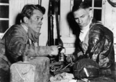 Varg-Olle Nygren och Tommy Price vid en pratstund över en dunk metanol. Landskampen 1951.