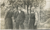 Tre personer står framför några träd i Heljered okänt årtal.
Från vänster: 1. Okänd ung kvinna. 2. Okänd ung man. 3. Svea* Gudiva Fredrika Johansson, Heljered Västergård.