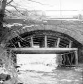 Kvarnagårdsbrons stenvalv. En träställning är rest under stenbron som går över Himleåns strömmande vatten. Kvarnagårdens vattenverk levererar kranvatten till stora delar av Varbergs centralort.
Bildtext (liggare): 