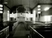 Interiör mot orgelläktaren i Hälleberga kyrka innan branden 1976.