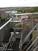 Byggnad vid Soabs industrianläggning i Mölndals Kvarnby, år 2007. Plattform med trappor, räcken och rörledningar. I bakgrunden ses även byggnader vid Gamla torget samt vid pappersbruket Papyrus. Anläggningen användes vid fototillfället av Hexion Speciality Chemicals Sweden AB.